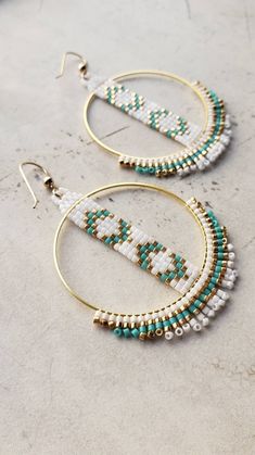 Classic pairings of crisp white, dark teal and shiny gold woven into chevron patterns and accented by short structured fringe. These were created for a dear friend who was performing for the first time on stage! She was incredible, but we all knew she would be! About 2.75 inches in length. Woven onto gold plated hoops and finished with 14k gold filled ear wires. Made to Order. Not available for wholesale. Beading Hoops Tutorial, Hoop Seed Bead Earrings, White Bohemian Small Hoop Beaded Earrings, Beaded Hoop Earrings Patterns, Beaded Crochet Patterns, Beaded Hoops Earrings, Seed Bead Earrings Tutorial, Beaded Hoop Earrings Tutorial, Seed Bead Hoop Earrings