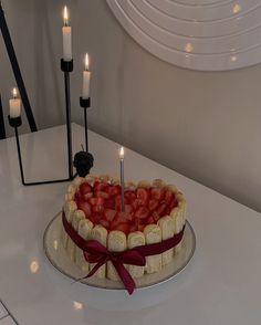 a cake with strawberries and candles on a table