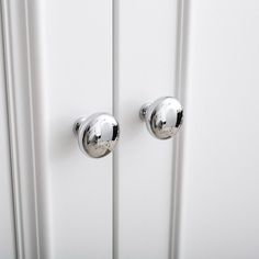 two chrome knobs on a white door