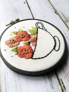 an embroidered hoop with some flowers on it