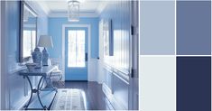 a hallway with blue walls and white trim, along with an entryway table in the center