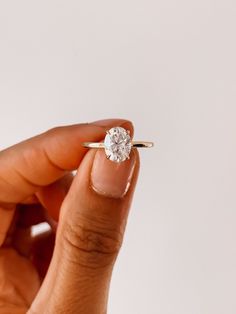 a person holding a ring with a diamond in it's middle and one hand on the other side