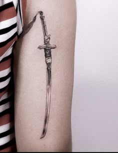 a woman's arm with a knife tattoo on it