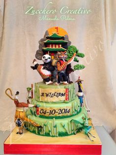 the cake is decorated with animals and people on it's tiered stand,