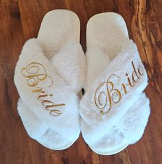 a pair of white slippers with the word bride written on them sitting on a wooden floor