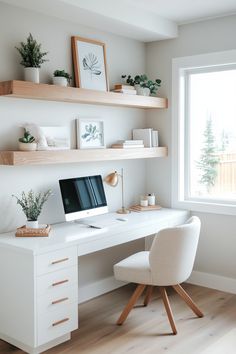 a white desk with a computer on top of it and shelves above the desk, along with potted plants