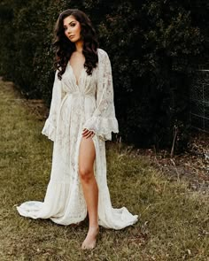 a woman in a white dress posing for the camera with her legs spread wide out