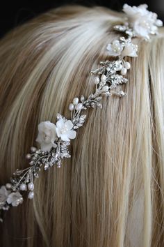 a woman with blonde hair wearing a white flower headpiece