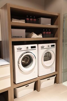 a washer and dryer in a room with shelves on the wall behind them