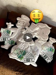 a bunch of money sitting on top of a bed next to a smiley face balloon