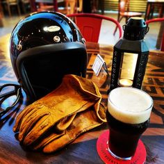 a helmet, glove and beer sitting on a table