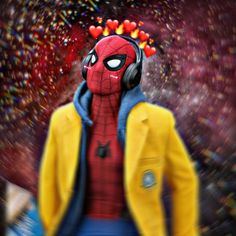 a spider - man with headphones on is standing in front of some confetti