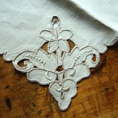 an embroidered piece of cloth on top of a wooden table