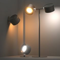 two lamps that are next to each other on a table in front of a wall