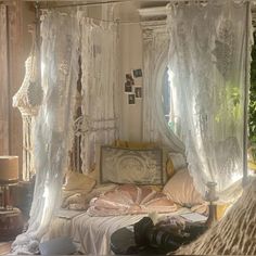 a bed with white curtains and pillows in a room