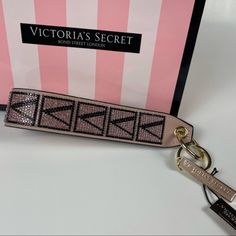 the victoria's secret keychain is in front of a pink and white box