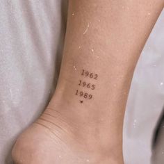 a person with a small tattoo on their foot that reads, 1932 - 2009 and has hearts