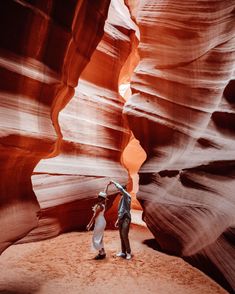 two people standing in the middle of a canyon