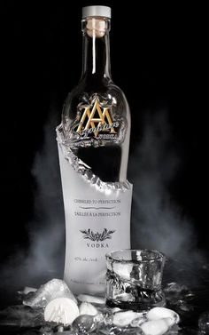 a bottle of vodka sitting on top of ice next to an empty glass cup and spoon