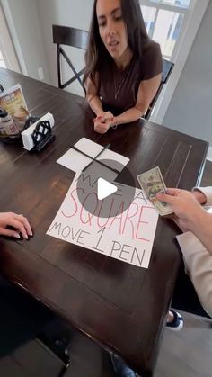 two women sitting at a table with some money