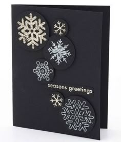 a black card with white snowflakes on it and the words seasons greetings