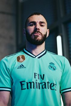 a bearded man in a green soccer uniform looking at the camera with an intense look on his face