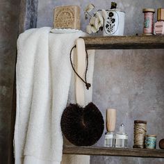 a white towel is hanging on a wooden shelf next to other items that are sitting on the shelves