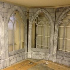 an unfinished room with stone walls and arched windows