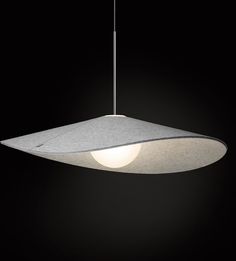 a white light hanging from a ceiling fixture in a dark room with black walls and flooring