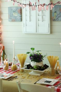 the table is set with food and wine for two people to eat together, while candles are lit