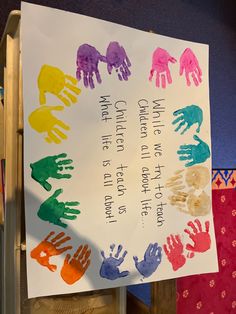 a white sign with colorful handprints on it that says, we celebrate the first time