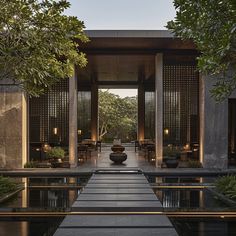 an outdoor area with tables, chairs and trees in the background is lit up by lanterns