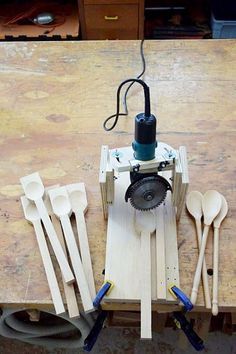 a table topped with lots of wooden utensils and a machine on top of it