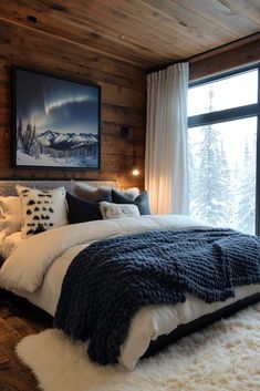 a bedroom with wood walls and white bedding in front of a large window that looks out onto the snowy mountains