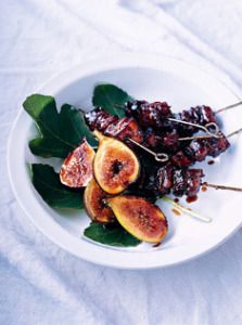 figs and other fruits on a plate with toothpicks in the foreground