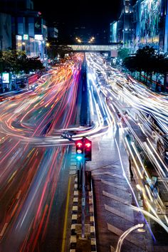 the city street is busy with cars and lights at night, as well as traffic