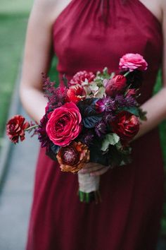 a woman in a red dress holding a bouquet of flowers