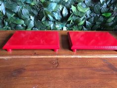 two red trays sitting on top of a wooden table