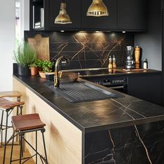 a kitchen with marble counter tops and gold pendant lights over the sink, along with bar stools