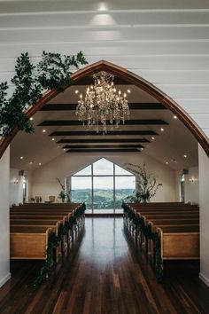 an empty church with wooden pews and chandelier