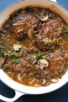 a pan filled with meat and mushrooms covered in gravy