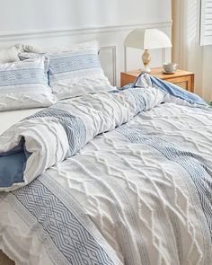 a bed with blue and white comforters in a bedroom