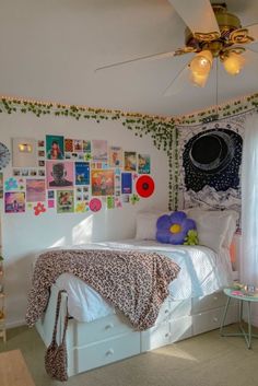 a bedroom with pictures on the wall and a bed in front of a ceiling fan