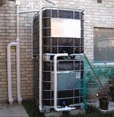 an air conditioner sitting next to a brick building with pipes running from it's side