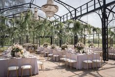 an outdoor venue with tables and chairs set up for a formal dinner or wedding reception