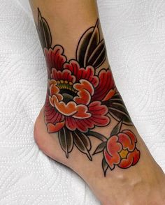 a woman's foot with a flower tattoo on the top and bottom of it