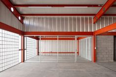 an empty room with red and white walls in the center, surrounded by grey bricks