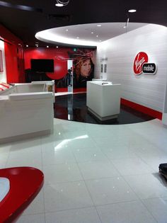 the interior of a hair salon with red and white walls, flooring and furniture