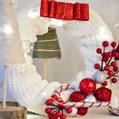 a white wreath with red and silver decorations