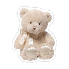 a white teddy bear with a bow around its neck